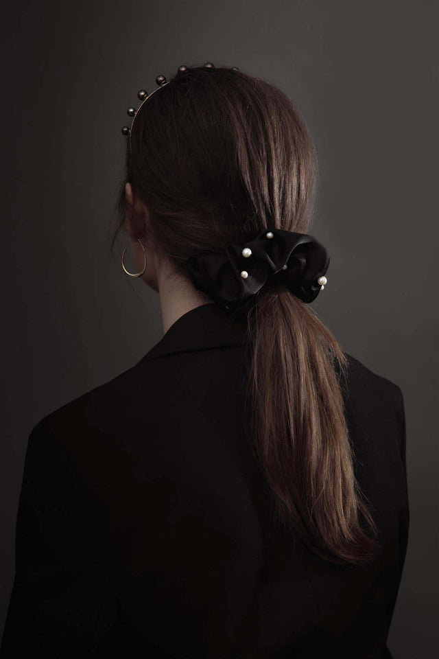 Lady wearing modern lux hair jewelry ONLY REAL SILK Scrunchie in black embroidered with fresh water pearl and ULA Tahitian pearl headband with her ponytail