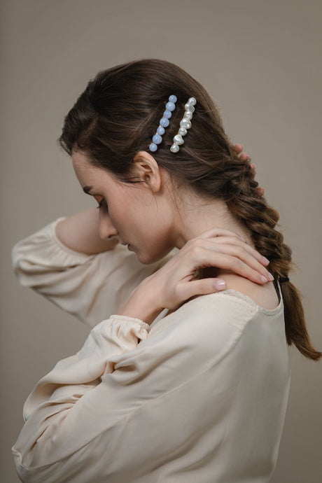 Model wearing modern Lux Hair Jewelry GIONNY Baroque Pearl Barrette and SELENE Blue Chalcedony Barrette on the side of her braided hair