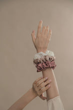 Load image into Gallery viewer, Model&#39;s hand with Modern lux hair jewelry ONLY REAL SILK Scrunchies in Pink, Champagne and white color 
